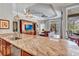 Open concept kitchen island has granite countertop and stainless steel dishwasher, overlooking living area at 16124 Suncrest Shores Dr, Odessa, FL 33556