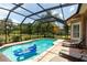 Sparkling pool with a screened enclosure and comfortable lounge chairs at 16124 Suncrest Shores Dr, Odessa, FL 33556