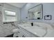 Modern bathroom featuring a marble vanity, black hardware, and a glass-enclosed shower at 1624 Chateau Dr, Clearwater, FL 33756