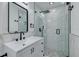 Modern bathroom featuring marble tile, glass shower, and sleek black fixtures at 1624 Chateau Dr, Clearwater, FL 33756