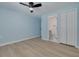 Light blue bedroom with ceiling fan, wood floors, and ensuite bathroom at 1624 Chateau Dr, Clearwater, FL 33756