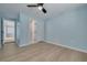 Light blue bedroom features wood floors, ceiling fan, and adjoining bathroom at 1624 Chateau Dr, Clearwater, FL 33756