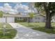 Charming single Gathering home featuring a well-manicured lawn, long driveway and attached garage at 1624 Chateau Dr, Clearwater, FL 33756