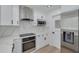 Modern kitchen with stainless steel appliances, marble backsplash, and range hood at 1624 Chateau Dr, Clearwater, FL 33756