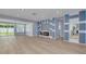 Spacious living room with wood floors, custom lighting, and a sliding glass door to the backyard at 1624 Chateau Dr, Clearwater, FL 33756