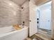 Bright bathroom with a tub, elegant gray tiling, and contemporary fixtures at 18001 Richmond Place Dr # 330, Tampa, FL 33647