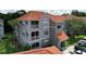 Gray condo building with orange tile roof, white balcony railings, and well-maintained landscaping at 18001 Richmond Place Dr # 330, Tampa, FL 33647
