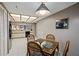 Dining area with a contemporary light fixture, a kitchen view, and seating for four at 18400 Gulf Blvd # 1105, Indian Shores, FL 33785