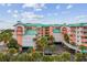 Exterior of condo building with tropical landscaping and ample parking space at 18400 Gulf Blvd # 1105, Indian Shores, FL 33785