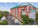 Exterior of condo building featuring balconies, lush landscaping, and ample parking at 18400 Gulf Blvd # 1105, Indian Shores, FL 33785