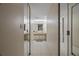 Hallway with tiled floors and mirrored closet doors leading to bathroom with vanity and dual sinks at 18400 Gulf Blvd # 1105, Indian Shores, FL 33785
