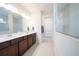 Modern bathroom with double vanity, wood cabinets and glass-enclosed shower at 18933 Sailors Delight Pass, Land O Lakes, FL 34638