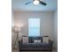 Small bedroom featuring a comfy sofa, window with blinds, and a ceiling fan at 18933 Sailors Delight Pass, Land O Lakes, FL 34638