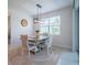 Bright dining area with modern light fixture, a table set for four, and sliding glass doors at 18933 Sailors Delight Pass, Land O Lakes, FL 34638