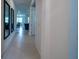 Long hallway with tile flooring, leading to the open-concept living area and bedrooms at 18933 Sailors Delight Pass, Land O Lakes, FL 34638