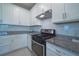 Well-equipped kitchen with granite countertops, white cabinets, and stainless steel gas range at 18933 Sailors Delight Pass, Land O Lakes, FL 34638