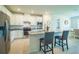 Bright kitchen features white cabinetry, stainless steel appliances, and a granite countertop island with seating at 18933 Sailors Delight Pass, Land O Lakes, FL 34638