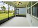 Enclosed lanai with a ceiling fan looks out onto the green lawn and blue sky at 18933 Sailors Delight Pass, Land O Lakes, FL 34638