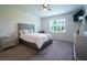 Serene main bedroom featuring a tufted headboard, a window view, and carpet floors at 18933 Sailors Delight Pass, Land O Lakes, FL 34638