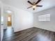 Bedroom with gray wood floors, white walls, a ceiling fan, and natural light from the window at 2152 74Th N St, St Petersburg, FL 33710