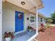 Close-up of the home's entrance, showcasing a vibrant blue front door with decorative wreath and potted plants at 2152 74Th N St, St Petersburg, FL 33710