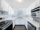 Well-lit kitchen features sleek white countertops, appliances, and ample storage space at 2152 74Th N St, St Petersburg, FL 33710