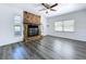 Living room featuring a stone fireplace, modern wood flooring, white walls, and bright windows at 2152 74Th N St, St Petersburg, FL 33710