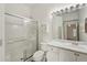 Clean bathroom with glass enclosed shower and white cabinets with marble countertop at 2436 Nantucket Harbor Loop # 104, Sun City Center, FL 33573