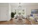 Bright dining area featuring a round table, chandelier and a bay window with views of the outdoor greenery at 2436 Nantucket Harbor Loop # 104, Sun City Center, FL 33573