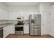 Bright kitchen featuring stainless steel appliances, granite countertops, and white cabinetry at 2436 Nantucket Harbor Loop # 104, Sun City Center, FL 33573