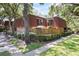 Charming townhouse featuring a private fenced patio and red-tiled roof, surrounded by lush landscaping and mature trees at 2626 2Nd Ct, Palm Harbor, FL 34684