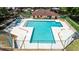 Community pool with a unique shape, lounge chairs, and nearby building at 2626 2Nd Ct, Palm Harbor, FL 34684