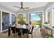 A dining room with a wooden table, six chairs, a ceiling fan, and large windows with an ocean view at 2802 Northpointe Ln, Tampa, FL 33611