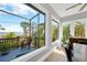 A dining room with views of the outdoor deck, landscaping, and water beyond at 2802 Northpointe Ln, Tampa, FL 33611
