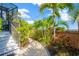 Beautiful landscaping with stone path, tropical foliage and brick wall leading to the screened porch at 2802 Northpointe Ln, Tampa, FL 33611