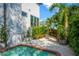 Backyard pool area with lush landscaping, a seating area, and privacy fencing at 2802 Northpointe Ln, Tampa, FL 33611