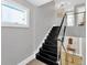 Modern staircase with black stairs, glass railing, and hardwood floors leading to the lower level at 2802 Northpointe Ln, Tampa, FL 33611