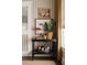 Stylish bar cart featuring liquor selection, plants, and art, situated in a room with patterned wallpaper at 2911 W Estrella St, Tampa, FL 33629