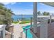 Backyard view featuring a luxurious pool, private boat dock, and lush landscaping at 297 1St W St, Tierra Verde, FL 33715