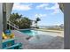 Swimming pool with waterfront views, lounge chairs, and tropical landscaping at 297 1St W St, Tierra Verde, FL 33715