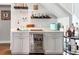 Charming bar area with custom cabinetry, beverage fridge, and stylish shelving perfect for entertaining at 297 1St W St, Tierra Verde, FL 33715