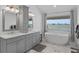 Serene bathroom featuring a standalone tub, double vanity, and a window with views of the water at 297 1St W St, Tierra Verde, FL 33715