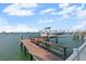 Boat dock with a boat on a lift sits over the water on a sunny day at 297 1St W St, Tierra Verde, FL 33715