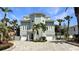 Gorgeous multi-story house featuring decorative windows, palm trees, and an interlocking brick driveway at 297 1St W St, Tierra Verde, FL 33715