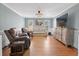 Bright living room featuring wood floors, decorative trim, comfortable seating, and an entertainment center at 297 1St W St, Tierra Verde, FL 33715