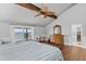 Bright main bedroom featuring wood floors, ceiling fan, and sliding glass doors to a deck overlooking the water at 297 1St W St, Tierra Verde, FL 33715