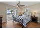 Cozy main bedroom featuring hardwood floors, a ceiling fan, and French doors leading to a private balcony with water views at 297 1St W St, Tierra Verde, FL 33715