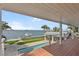 Enjoy panoramic water views from this expansive outdoor deck, overlooking a pool, private dock, and lush landscaping at 297 1St W St, Tierra Verde, FL 33715