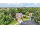 Aerial view of home highlighting mature trees, landscaping, and a paved driveway leading up to an attached garage at 3013 Crest Dr, Clearwater, FL 33759