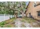 Spacious backyard with mature trees, playset, shed, and white fence, offering privacy and outdoor enjoyment at 3013 Crest Dr, Clearwater, FL 33759